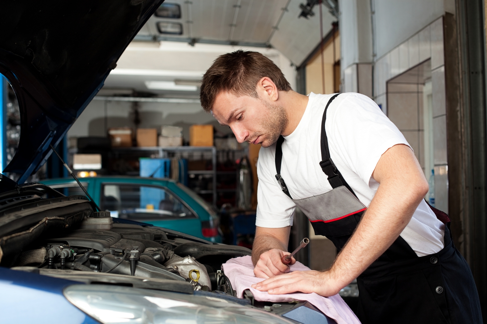 An automobile specialist deals with. Автослесарь. Техническое обслуживание автомобиля. Молодой автомеханик. Машина автомеханика.